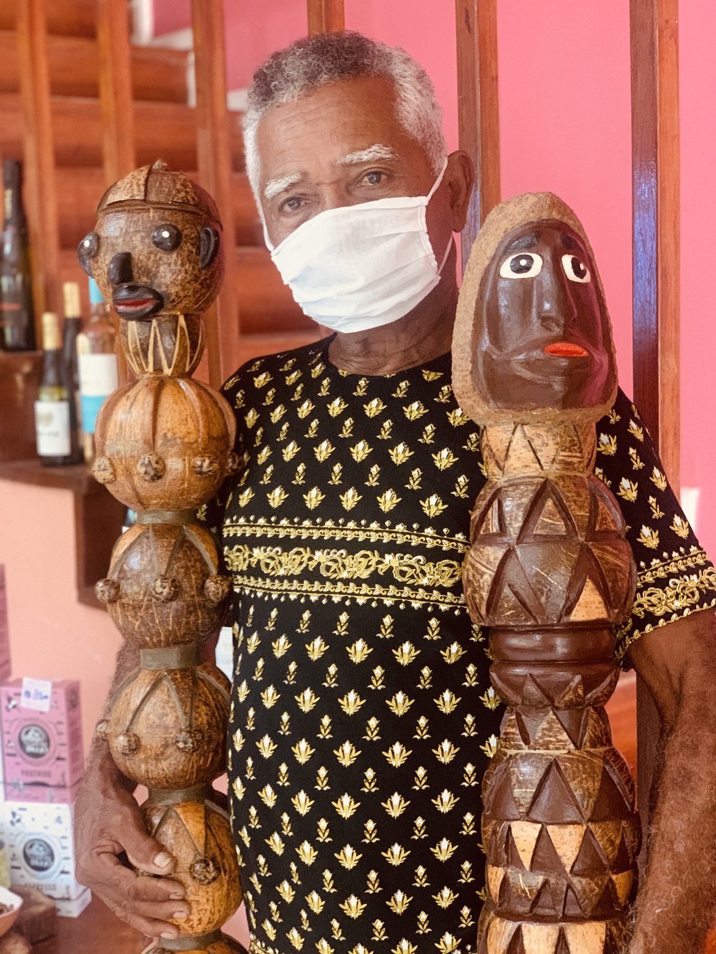 Artesão com bonecos esculpidos em coco
